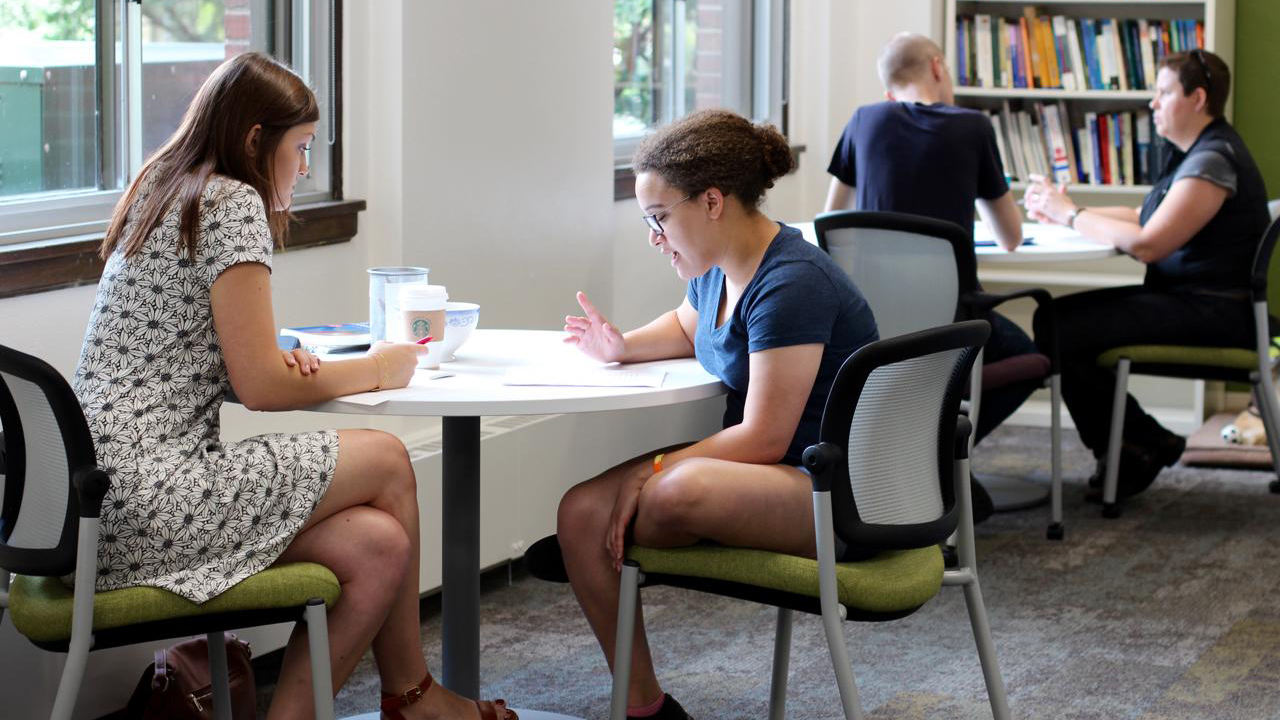 Consultant sitting at tables working with writers.