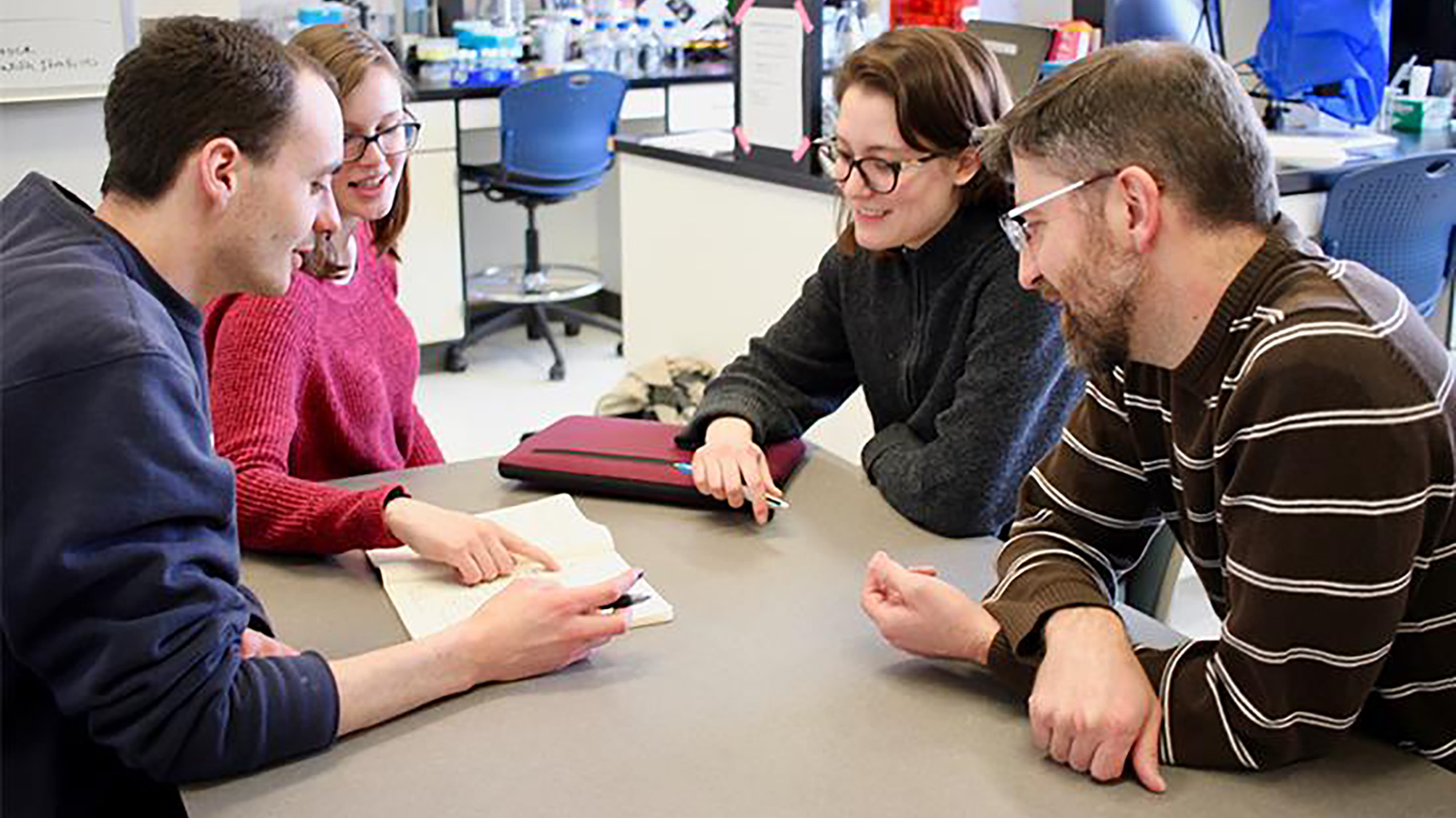 Writing fellows working with a faculty partner in a lab.